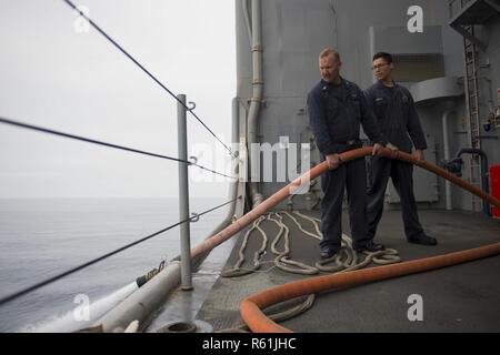 PACIFIC OCEAN (May 4, 2017) Hull Technician 1st Class Jeff Kinard, a Boerne, Texas native, and Damage Control Fireman Jose Garcia, a Farmington, New Mexico native, both assigned to the engineering department of amphibious dock landing ship USS Pearl Harbor (LSD 52), drain a fire main off the ship’s boat deck. More than1,800 Sailors and 2,600 Marines assigned to the America Amphibious Ready Group (ARG) and the 15th Marine Expeditionary Unit (MEU) are currently conducting a Composite Unit Training Exercise (COMPTUEX) off the coast of Southern California in preparation for the ARG’s deployment la