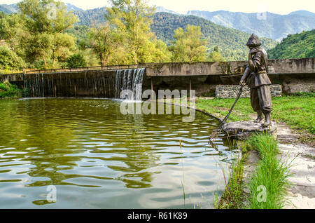 Dilijan, Armenia, August 24, 2018:Sculpture of fisherman with a net in an artificial reservoir on the Aghstev river, near the restaurant, Golden fish, Stock Photo