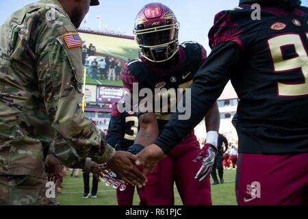 Soldiers assigned to 703rd Brigade Support Battalion, 2nd Armored Brigade Combat Team, 3rd Infantry Division, shook hands with Florida State University football players before the Seminoles vs. Boston College  Eagles game, Nov. 17, at Doak Campbell Stadium. Military appreciation day provides Soldiers, retirees, and family members recognition for their selfless service given to the Nation. Stock Photo