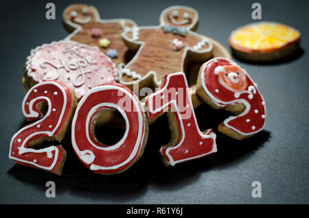 Christmas card on wood background gingerbread red numbers 2019 with slices of orange and gingerbread Mans Stock Photo
