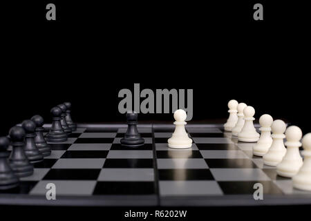 Portrait of chess pawn on the chessboard. isolated on the black background. Stock Photo
