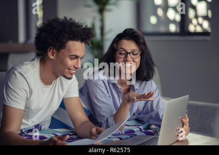 Worried young couple discussing bills at home Stock Photo