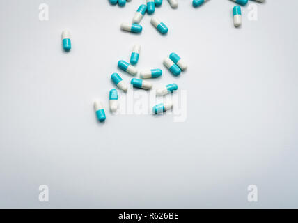 Blue-white capsule pills spread on white background. Pharmaceutical products. Global healthcare concept. Antibiotic drug resistance concept. Superbug  Stock Photo