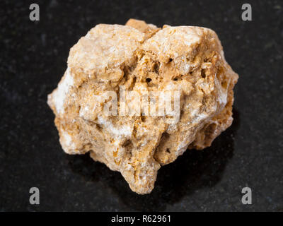 rough travertine stone on dark background Stock Photo