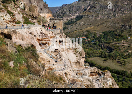 VARDZIA, GEORGIA - SEPTEMBER 25, 2018: Ancient cave monastery Vardzia, tourists pass through ruins of bell tower Stock Photo