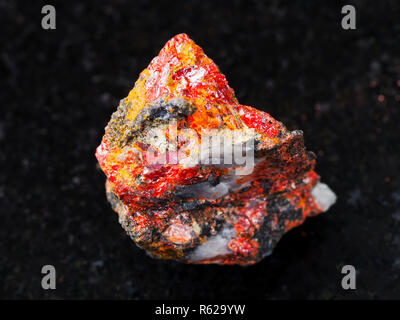 rough Realgar stone on dark background Stock Photo