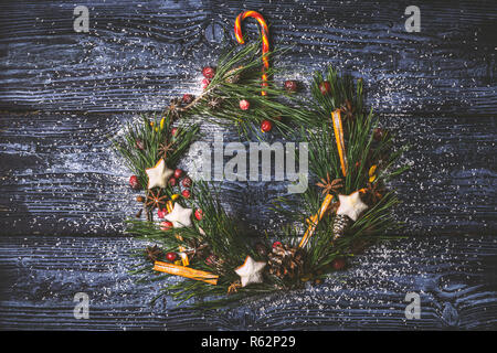 Christmas wreath with cookies , berries, spices   on the wooden background Stock Photo