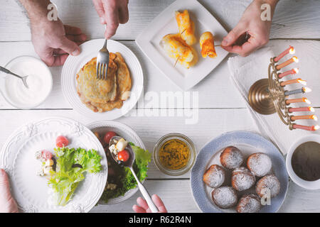 Traditional Hanukkah dishes on the white wooden table top view Stock Photo