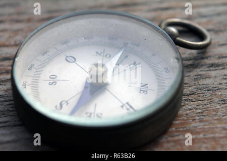 close up view of grunge compass points to true north  on wooden background Stock Photo