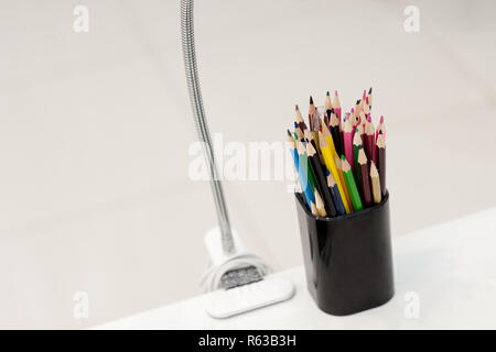 Many crayons with different colors. Back to school. Colored pencils in an glass Stock Photo