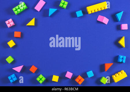 Baby kid toys background. Colorful plastic construction blocks and wooden cubes on blue background Stock Photo