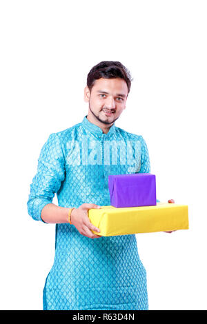 Indian man in ethnic wear and Holding gift box in hand , isolated over white background Stock Photo