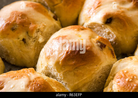 Traditional Easter hot cross buns in a oven plate on wooden table-Close up Stock Photo