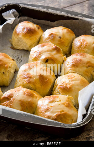 Traditional Easter hot cross buns in a oven plate on wooden table Stock Photo