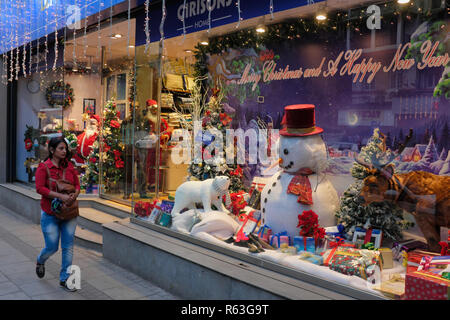 A woman walks past a shop in Mumbai, India, decorated for Christmas, the country's Christian minority's most important holiday Stock Photo