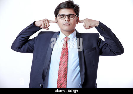 Young Indian business man covering ears Stock Photo