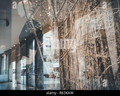 Rimini, italy, December 2018 maniquin is  shown on a clothing shop showcase. People walks for the street. Christmas atmosfere, Christmas showcase moun Stock Photo