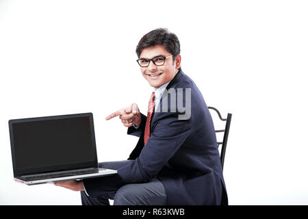 Young Indian man showing laptop screen Stock Photo
