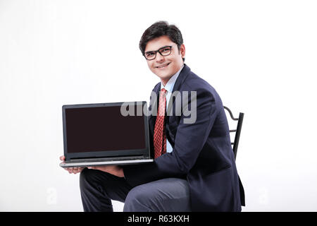 Young Indian man showing laptop screen Stock Photo