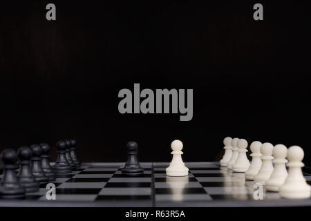 Picture of chess pawns on the chessboard. isolated on the black background. Stock Photo