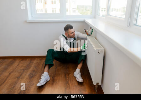 Plumber installing a new radiator Stock Photo