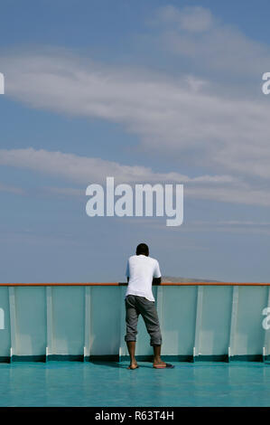 african man standing on the stern of a ship Stock Photo