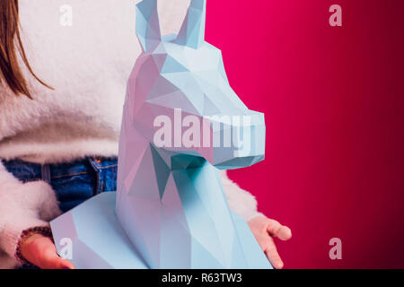 Fashion kid. Designer collection. White big unicorn origami made paper. Girl in beautiful pink dress. Studio shot. Stock Photo