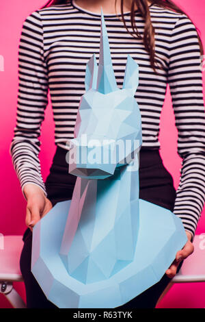 Fashion kid. Designer collection. White big unicorn origami made paper. Girl in beautiful pink dress. Studio shot. Stock Photo