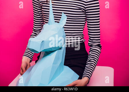 Fashion kid. Designer collection. White big unicorn origami made paper. Girl in beautiful pink dress. Studio shot. Stock Photo