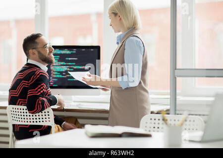 Application programmers discussing code for new app Stock Photo