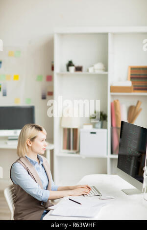 Concentrated woman coding information on computer Stock Photo