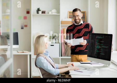 Programmers laughing while discussing new software Stock Photo