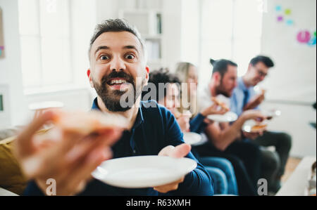Group of young businesspeople having lunch in a modern office. Stock Photo