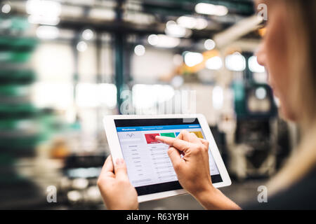 An industrial woman engineer in a factory using tablet. Stock Photo