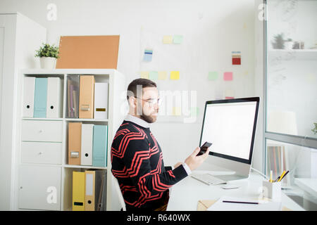 Serious man checking message on phone in office Stock Photo
