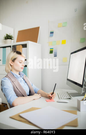 Lady manager making notes on sticker Stock Photo