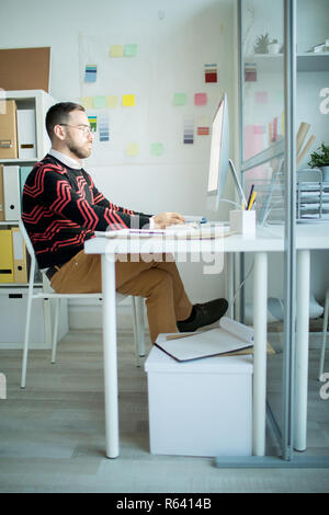 Serious businessman in fashionable outfit working alone in offic Stock Photo