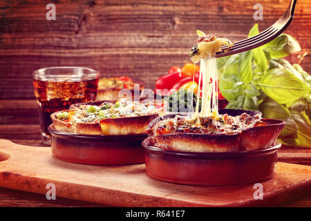 Spinach casserole bake with cheese and tomato on wooden background, close up vintage view Stock Photo
