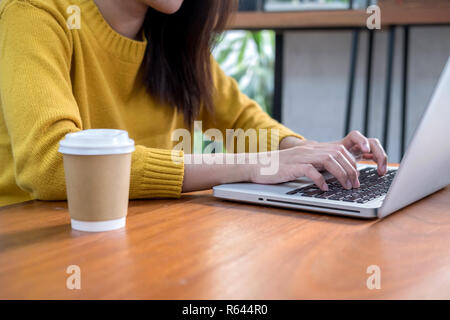 Online business concept. Woman hand using computer laptop in coffee shop. Stock Photo