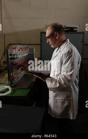 Worker working while using digital tablet in factory Stock Photo