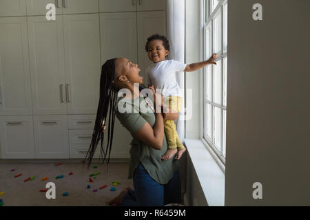 Mother and son playing near window Stock Photo