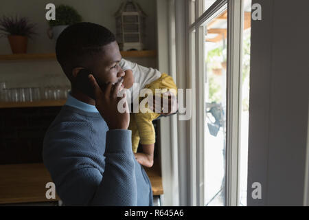 Father with his son in his arms talking on the phone Stock Photo
