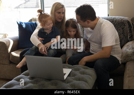 Family interacting with each other on sofa in living room Stock Photo