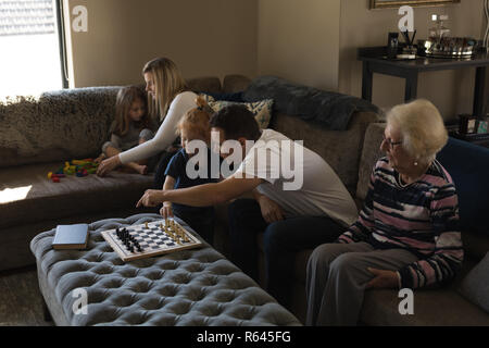 Multi generation family playing games on sofa in living room Stock Photo