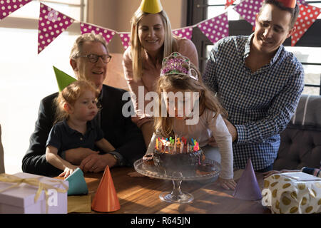 Multi-generation family celebrating birthday in living room