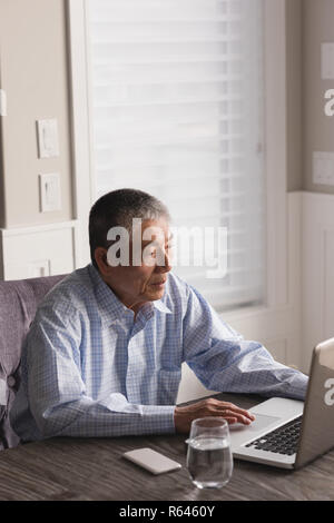Senior man using laptop on table Stock Photo