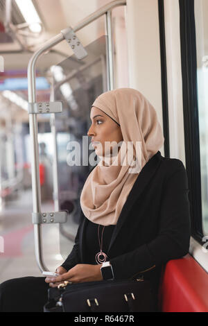 Woman using mobile phone while travelling in train Stock Photo