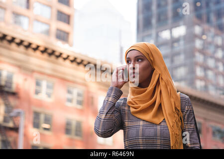 Woman talking on mobile phone in city Stock Photo