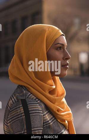 Thoughtful woman standing in city Stock Photo