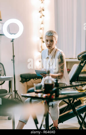 Short-haired young lady sitting at work at the end of the day Stock Photo